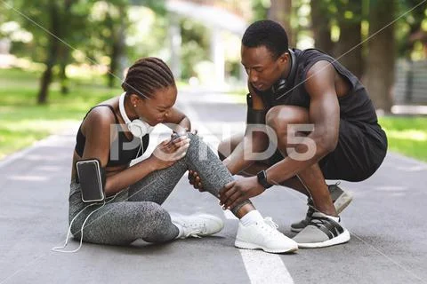 Sport Injury. Woman Suffering From Knee Trauma While Jogging With Boyfriend Stock Photos