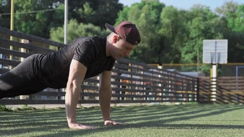 Sport man in cap doing push up at workout training at sunny morning outdoors 스톡 동영상 115025241