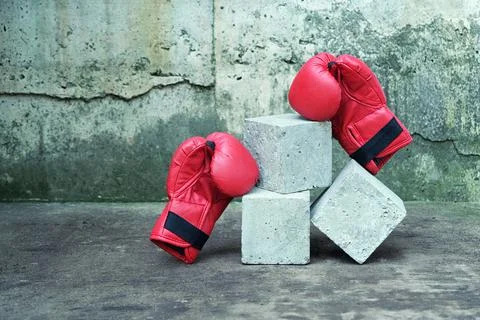 Sport mock up concrete cube empty podium surrounded with red boxing gloves on Stock Photos