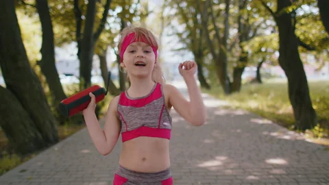 Sport runner jogger child girl listen bluetooth music speaker dancing to camera Stock Footage