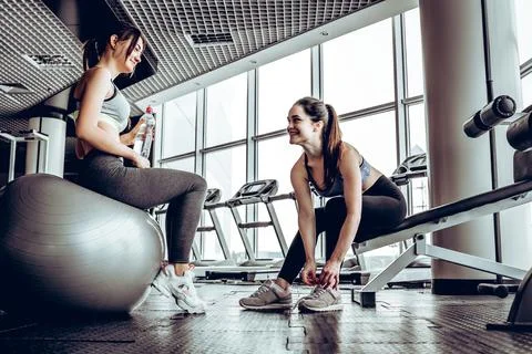 Sport woman sitting and resting after workout or exercise in fitness gym Stock Photos