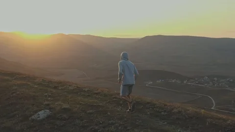 Sporting an evening jog on the top of a hill amid the sunset in the mountains 스톡 동영상 129608593