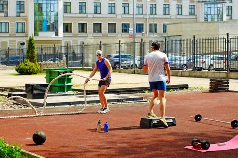 Sporting young men doing some crossfit exercises with ropes outdoors Stock Photos