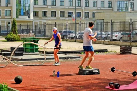 Sporting young men doing some crossfit exercises with ropes outdoors Stock-Fotos