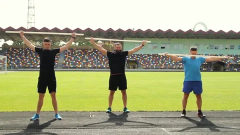 Sportive man, using pilates exercise body stick or bar while having workout at Stock Footage 130797545