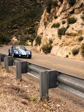 Sports Car Driving Through on Mountain Highway Stock Photos