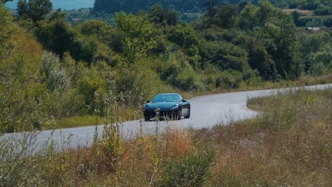 Sports car Maserati GT driving on countryside road Stock Footage