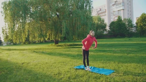 Sports girl training gymnastics in the park in 4K Stock Footage