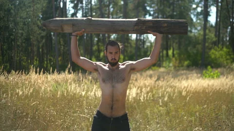 A sports guy performs strength exercises in nature, man pumps his muscles Stock Footage 93271369