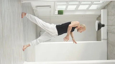 Sports man performs elements of modern dance from a white studio Video stock 159854835