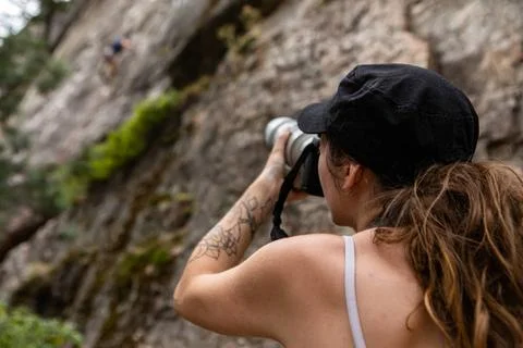 Sports photographer snaps rock climber An over the shoulder view of a spor... Stock Photos