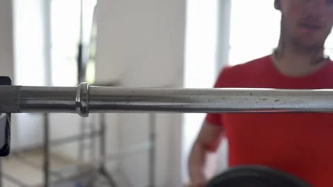 Sportsman adding weight to barbell changing black plates in slow motion., Stock Footage 154305883