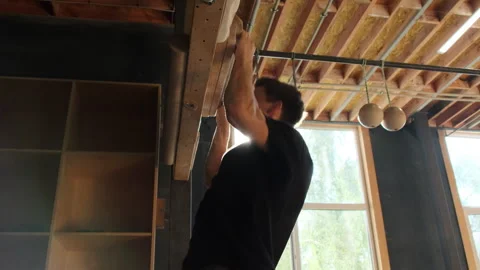 Sportsman does pull up hanging on climbing board in gym Stock Footage 264775670