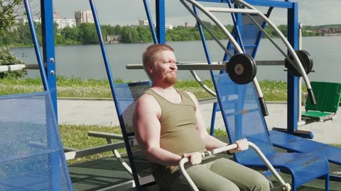 Sportsman doing exercises for muscles on exercise machines in outdoor gym. Stock Footage 172313488