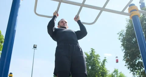 Sportsman doing pull ups exercise at park Stock Footage 141194321