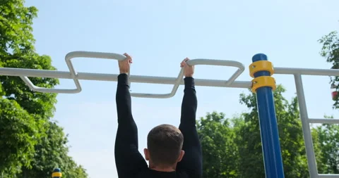 Sportsman doing pull ups exercise at park Stock Footage 141199561