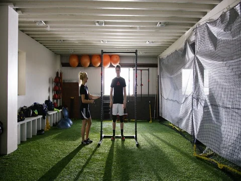 Sportsman doing pull-up while trainer monitoring at fitness studio 動画素材 78201531