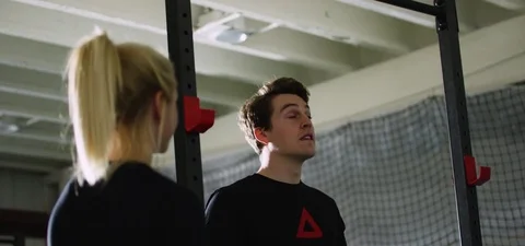 Sportsman doing pull-up while trainer monitoring at fitness studio 動画素材 78202271