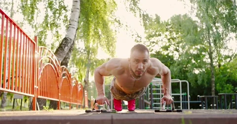 Sportsman doing push-ups exercise at outdoor gym.Shirtless man practicing push Stock Footage 157094151