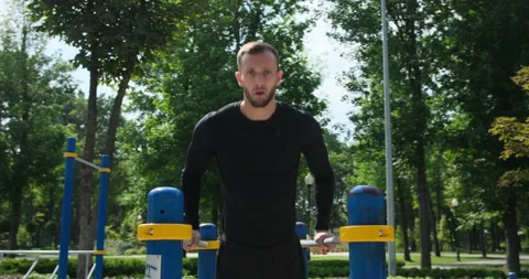 Sportsman doing triceps dip on parallel bars at park Video stock 141201269