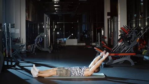 Sportsman doing twist sit-ups exercises lifting hands legs floor mat Stock Footage
