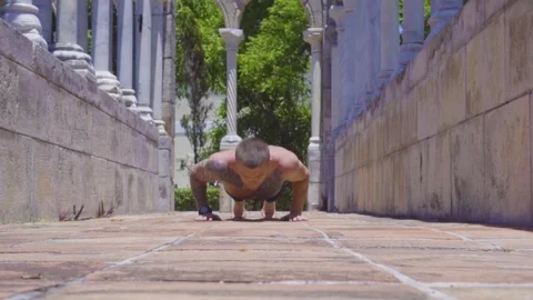 Sportsman makes pushups among bricks and ancient columns Stock Footage 112698036