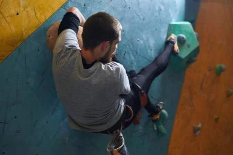 Sportsman moving at artificial rock wall, preparing to extreme mountain ascend Stock Photos