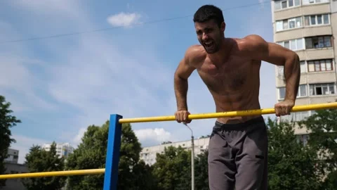 Sportsman performing dynamic pull-up workout, showcasing strength Stock Footage 317234646