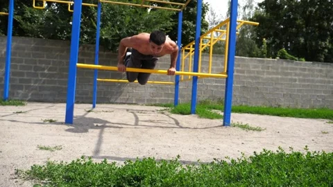 Sportsman performing dynamic workout routine on parallel bars, showcasing Video stock 321054087