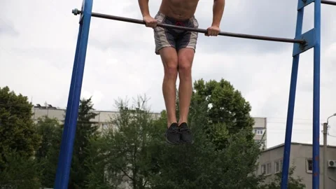 Sportsman performing dynamic workout routine on parallel bars, showcasing Stock-Footage 329754670