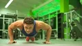 The sportsman push up from the floor in the fitness center 4k or 4k+ Resolution