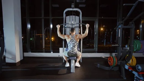 Sportsman working out doing exercise on weight-lifting training machine in gym Stock Footage 81949395