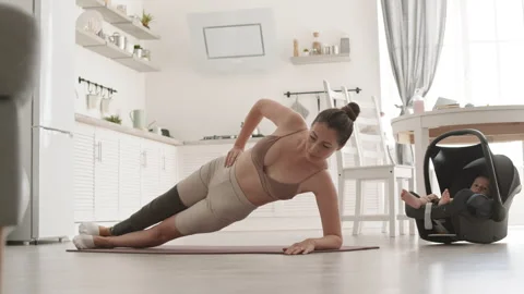 Sportswoman with Disability Doing Side Plank while Babysitting Video stock 306646507