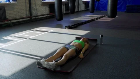 Sportswoman on exercise mat doing abs workout in gym. Muscular female athlete 库存影片 105926531