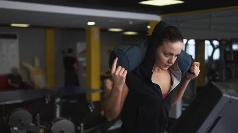 The sportswoman goes a sporting step on treadmill with a load on her shoulders. Stock Footage