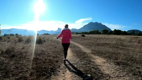 Sportswoman run through mountain path top against beautiful landscape Stock Footage 146621670