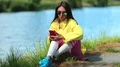 Sportswoman sits near pond and uses his smartphone HD Footage
