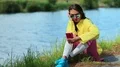Sportswoman sits near pond and communicates via smartphone HD Footage