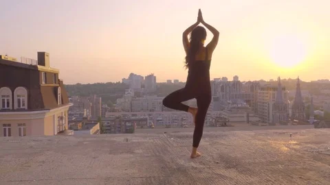 Sporty brunette doing yoga exercise on the rooftop at sunset Stock Footage