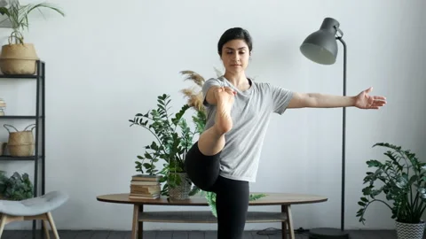 Sporty Curly Haired Woman Does Yoga Stretching Exercises. Slender girl does yoga Stock Footage 155761663