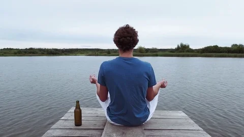 Sporty guy caucasian appearance practicing yoga on the nature near the lake Stock Footage 81146580