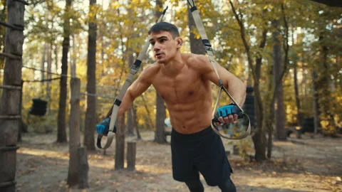 Sporty man doing exercise for hands and for all body. Workout with TRX system Stock Footage 165225445