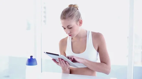 Sporty smiling blonde using tablet Stock Footage 32879476