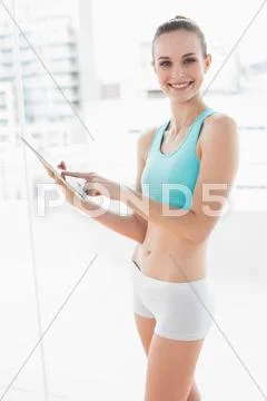 Sporty smiling woman using a tablet Stock Photos