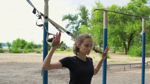 Sporty woman doing trx suspension training in a park Stock Footage