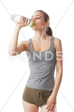 Sporty woman in fitness dress is drinking water from a water bottle Stock Photos