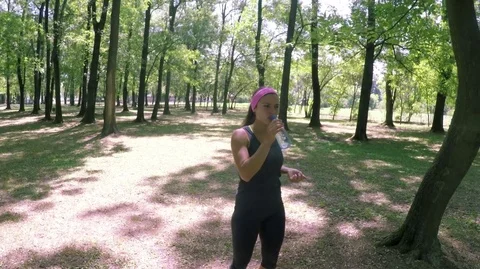 Sporty woman refreshing by water after fitness outdoor Stock Footage