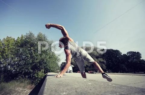 Sporty young man jumping in summer park Stock Photos