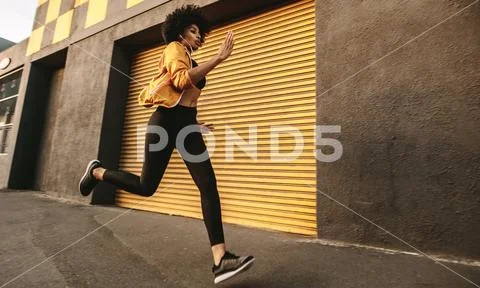 Sporty young woman sprinting outdoors Stock Photos