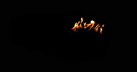 A spot of real flames starts to burn on a black background. Isolated Igniting Stock Footage 142063749